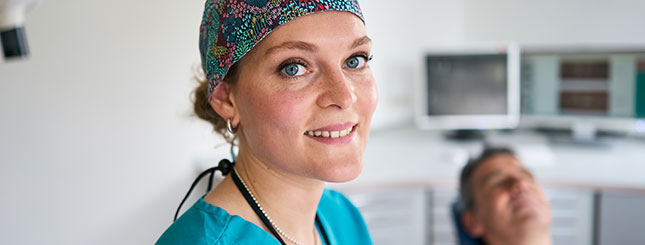 Zahnärztin Frau Brejcha mit Patient im Hintergrund